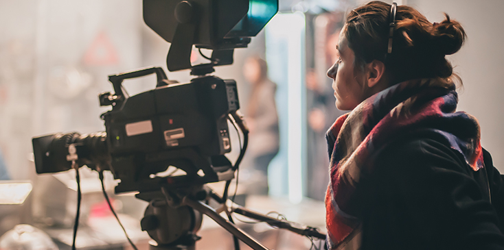 a woman reviews footage on a video camera