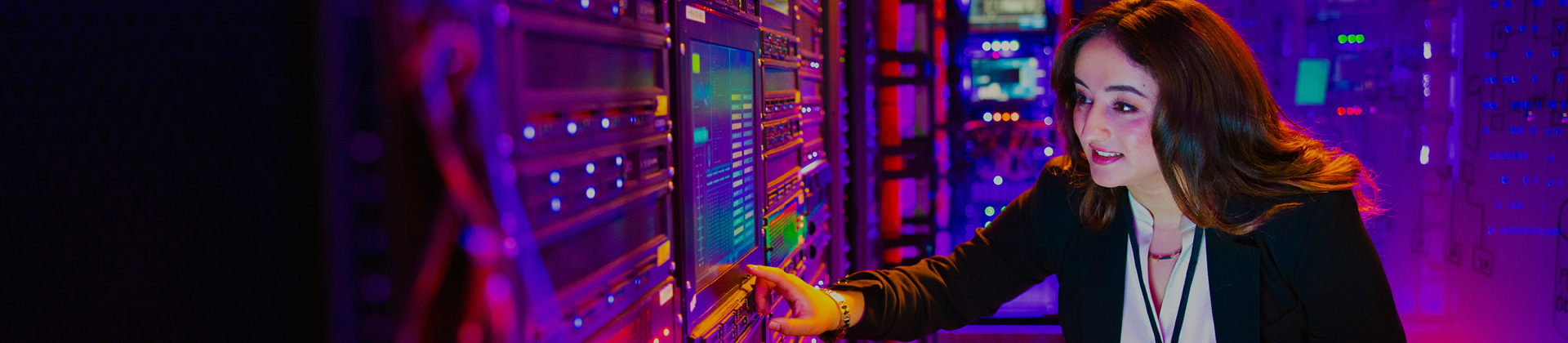 woman in server room pointing at screen