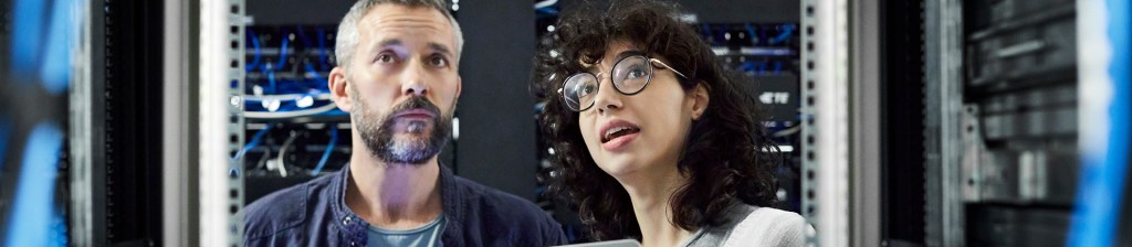 man and woman in server room looking up