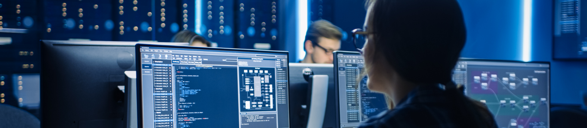 People working on computer in dark room with server racks