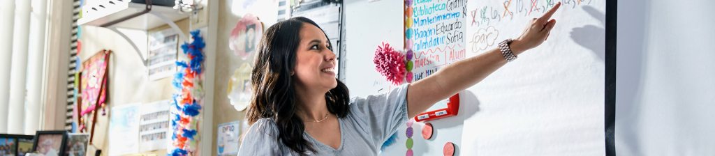 Teacher pointing at whiteboard in classroom