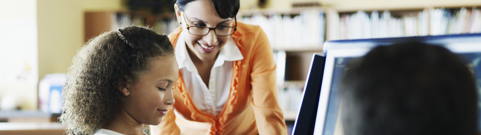 woman works with a girl on a computer