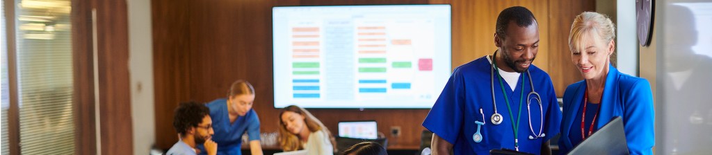 Doctors in boardroom with projection of information