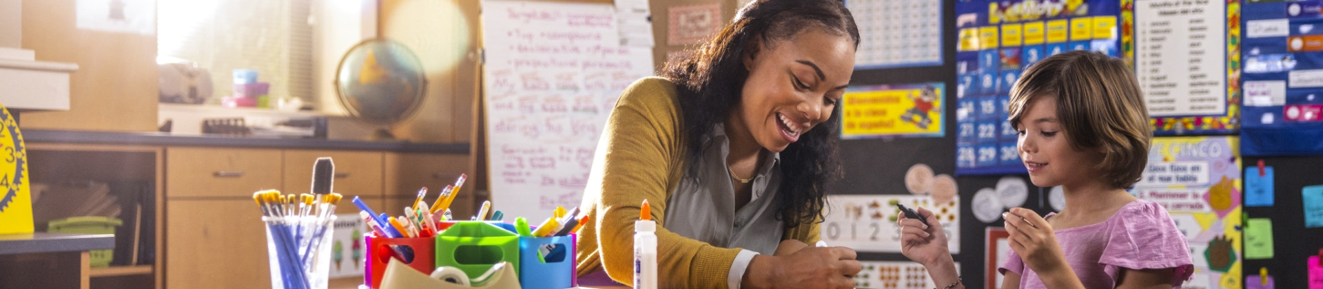 a teacher works with a student in a classroom