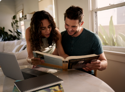 two people looking at large book