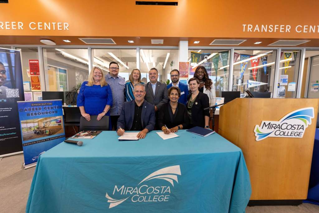 MiraCosta College booth with staff behind table